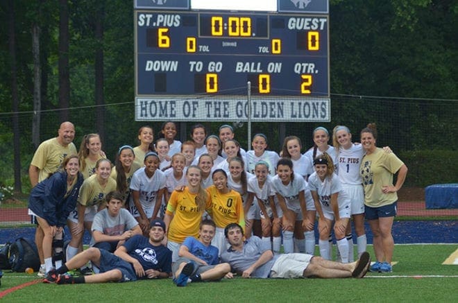 St. Pius X High School head soccer coach Sara Geiger, back row far right, and assistant coach Mike Mey, back row far left, join the girls team for a photo after a 6-0 state semifinal victory over Decatur High School. St. Pius went on to defeat Blessed Trinity High School 1-0 for its second straight state championship, and it's fifth in six years.
