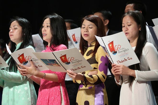 Vietnamese choir members provide music during the morning service at the Eucharistic Congress, June 21, as the procession enters the hall. Photo By Michael Alexander