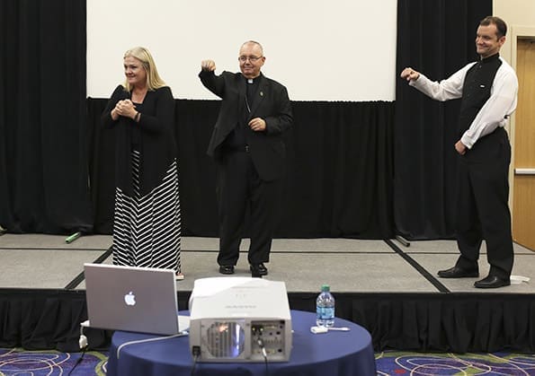 Displaying the word for “yes” in the American Sign Language (ASL) track, Bishop David Talley, center, encourages the deaf community to enjoy their experience at the Eucharistic Congress with the help of Lisa Palak, left, and Father Shawn Carey. Father Carey is director of the Office of the Deaf Apostolate for the Archdiocese of Boston. Photo By Michael Alexander