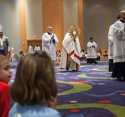 Archbishop Wilton D. Gregory visited the Kid Track on Saturday afternoon, June 21, during the 2014 Eucharistic Congress. He processed in with the Blessed Sacrament and led a period of adoration with the children. Photo By Thomas Spink