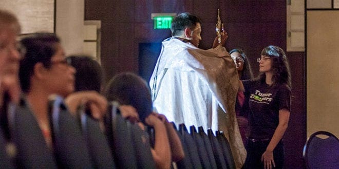 Jennifer Osorio, 18, from San Felipe de Jesús Mission in Forest Park, approaches the Blessed Sacrament during adoration at Friday night's "Revive!" track. Photo By Thomas Spink