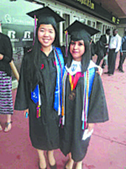 Olga Lopez-Gomez, right, celebrates graduation with her classmate Sandi Lam, who graduated third in the class.