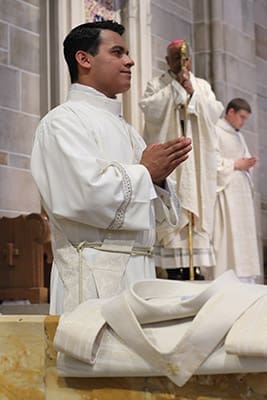 Ordination candidate Rey Pineda, foreground, stands with the entire congregation during the reading of the Gospel from the Book of Luke. Photo By Michael Alexander