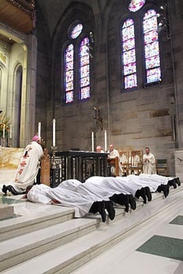 The six ordination candidates to the priesthood prostrate themselves before the altar during the Litany of the Saints. Photo By Michael Alexander