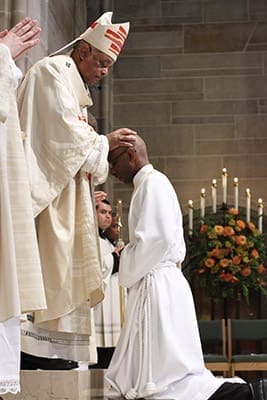 Archbishop Wilton D. Gregory lays hands upon ordination candidate Desmond Drummer during the June 28 rite of ordination to the priesthood at the Cathedral of Christ the King, Atlanta. Photo By Michael Alexander