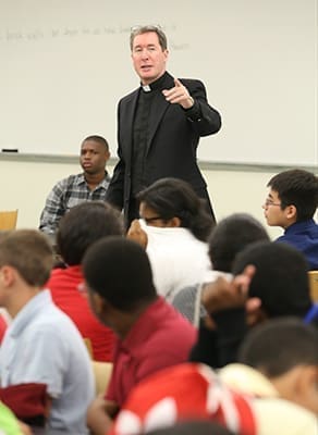 Jesuit Father James Van Dyke, principal of Cristo Rey Atlanta Jesuit High School, Atlanta, addresses the students during morning orientation. The school year and business training institute began Aug. 4. Photo By Michael Alexander