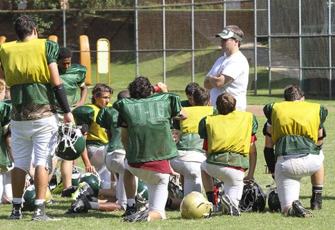 David Rosenzweig, standing right, addresses the Holy Spirit Preparatory School football team during a July 30 practice. The team plays its first game at home on Aug. 22. Photo By Michael Alexander