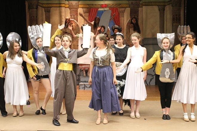In the “Be Our Guest” scene during the Holy Cross Church theater ministry drama camp rehearsal, Lumiere, front row, left, played by Neal Belden, and the castle's staff of magical objects attempt to make Belle, front row, right, played by Shea Jones, welcome at the Beast's castle. The proceeds from the three productions of Disney’s "Beauty and the Beast Jr." benefited the parish’s food pantry. Photo By Michael Alexander