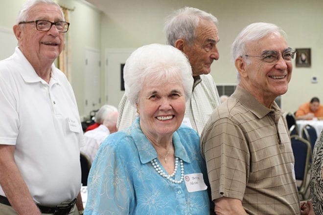 (Clockwise, from center) Betsy Hein was one of the founding members of Holy Cross Church in 1964. Today she is a member of St. John Neumann Church, Lilburn. Standing in the food line with Hein during the luncheon that followed the 50th anniversary founders Mass are retired Deacons Walter Bedard and Mike Jones, along with Holy Cross Deacon Thomas Silvestri. Photo By Michael Alexander