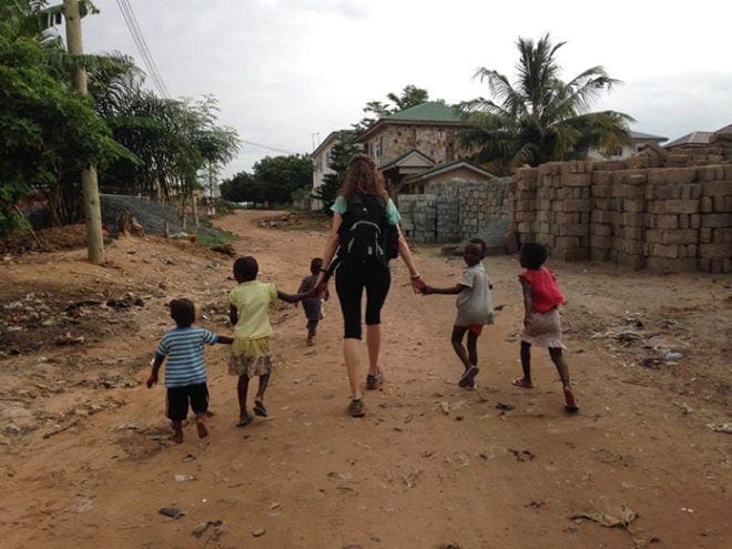 Emily Ice, a second-grade teacher at St. John Neumann Regional School in Lilburn, spent the summer in Ghana, West Africa, working for the University of Notre Dame and Edify to help students use computer labs. Above, she takes a stroll with children who live near one of the schools.