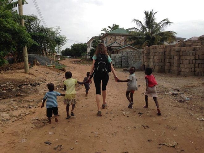Emily Ice, a second-grade teacher at St. John Neumann Regional School in Lilburn, spent the summer in Ghana, West Africa, working for the University of Notre Dame and Edify to help students use computer labs. Above, she takes a stroll with children who live near one of the schools. 