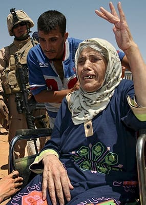 An elderly Iraqi woman fleeing violence gestures at the Al Waleed refugee camp in Iraq Aug. 19. One group of sick, elderly Iraqi Christians said they defied terrorist demands to convert to Islam or be killed. CNS photo/Morris Bernard 