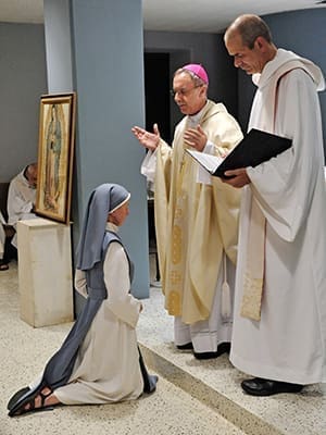 Sister Mary Beatrice Raphael professes simple vows Aug. 15 to Bishop Luis R. Zarama as a consecrated woman to live the eremitic life. Trappist Father Augustine, right, assisted at the service. Photo By Lee Depkin