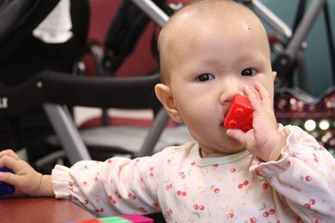 Eight-month-old Fatima plays in the lobby of Catholic Charities Atlanta’s Northlake Office Park location. Her family, originally from Afghanistan, was assisted by the Catholic advocacy organization during their resettlement process. Photo By Michael Alexander