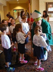 Bishop Luis R. Zarama warmly greets young students after celebrating Mass at St. Brigid Church, in Johns Creek, on Sept. 5. Holy Redeemer School opened 15 years ago and was celebrating its anniversary.