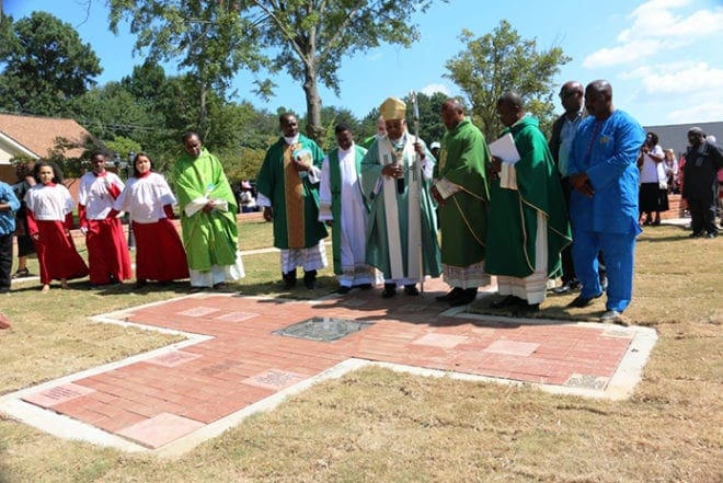 Archbishop Wilton D. Gregory, center, blesses the cross, inlaid with engraved bricks, at Christ Our Hope Church's new memorial garden. The Lithonia parish created the garden as part of its 30th anniversary celebration. Parishioners are invited to donate bricks in the garden in memory of loved ones or friends. Photo By Byron Henry