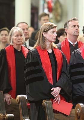 Judge Elizabeth L. Branch of the Georgia Court of Appeals, foreground, Judge Doris L. Downs of the Superior Court of Fulton County, background left, and Judge Shawn Bratton of the State Court of Gwinnett County, background right, stand with the congregation during the reading of Gospel. Photo By Michael Alexander