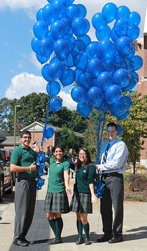 (L-r) Students Adisson Maalouf, Ana Paula Sanchez-Mejorada, and So Yoon Kim mark the occasion with Ed Lindekugel, Pinecrest upper school principal. Photo By Alison Batley