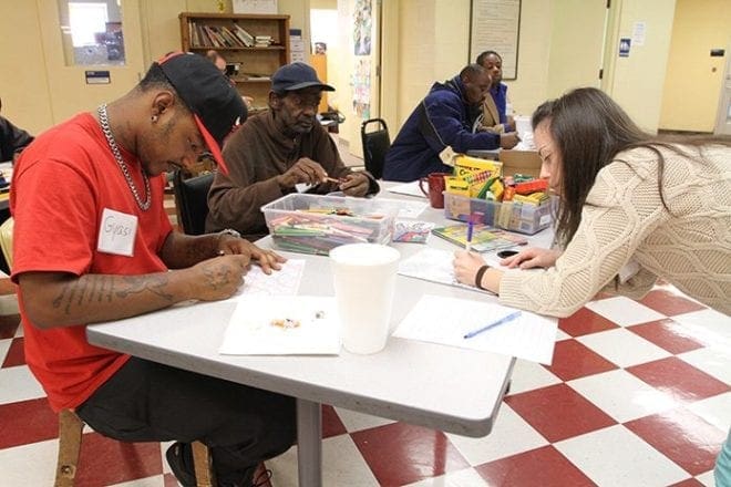 (Counterclockwise, foreground) Liza Kravets, a senior nursing student at Emory University, Atlanta, participates in the Wednesday morning therapeutic art session with Gateway Center residents Perry Middleton and Gyasi Phillips. Mercy Care has a clinic on the premises for treating the homeless men and women. Photo By Michael Alexander