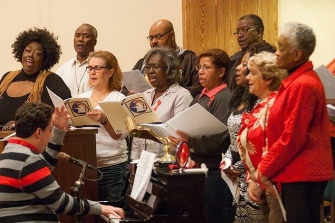 Nick Dragone, director of music/liturgy at St. Philip Benizi Church, Jonesboro, left, leads a parish choir. The World AIDS Day Mass is sponsored by Justice & Peace Ministries of the Atlanta Archdiocese to pray for those who have died, those who are living with HIV/AIDS, their caregivers, families and friends, those who are in HIV/AIDS ministry and those who are working to find a cure. Photo By Thomas Spink