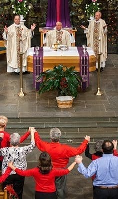 Bishop David P. Talley celebrates the archdiocesan World AIDS Day Mass at St. Philip Benizi Church, Jonesboro, on Dec. 3, assisted by Father John Koziol, OFM Conv., pastor, left, and Father John Adamski, right. World AIDS Day is Dec. 1 and highlights that millions still suffer from the disease worldwide. Photo By Thomas Spink