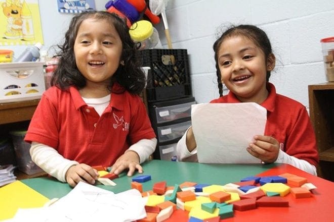 Brikel Tomay, left, and Kelly Garcia have fun while working on a numbers project in their Solidarity School classroom for 4-year-old preschool students.