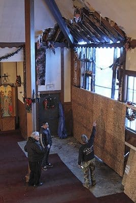 Father Philip Scott, left center, pastor of Epiphany Byzantine Catholic Church, observes the damage to the Roswell church’s ceiling and wall with his maintenance crew. Early Sunday morning, Dec. 14, an arsonist allegedly set the house of worship on fire. Photo By Michael Alexander