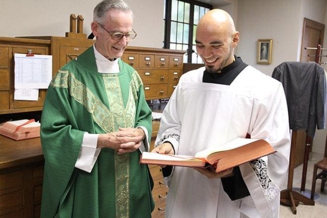 Father John Kieran, a priest of 47 years, and Carlos Cifuentes, a seminarian studying at Mundelein Seminary in Illinois, gather in the sacristy at the Cathedral of Christ the King, Atlanta. Priest support and retirement care and seminarian education are two ministries that are supported by the Archbishop’s Annual Appeal. Photo By Michael Alexander
