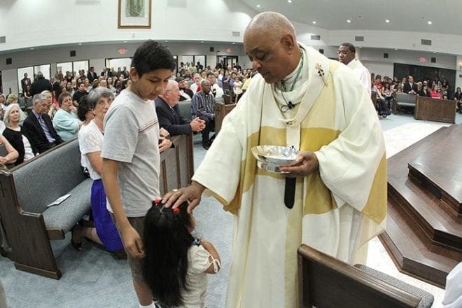 Archbishop Gregory extends a blessing to a little girl during the 2012 Mass of dedication at St. Francis of Assisi Church in Cartersville. Photo By Michael Alexander