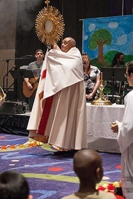 Archbishop Wilton Gregory blesses the children during the Kids Track at the 2013 Eucharistic Congress. Photo by Thomas Spink