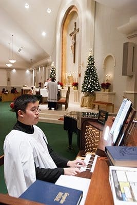 Andrew Leung, music director at St. Pius X Church, Conyers, plays during Christmas midnight Mass. The parish recently completed the first phase of renovations to the sanctuary. Photo by Thomas Spink