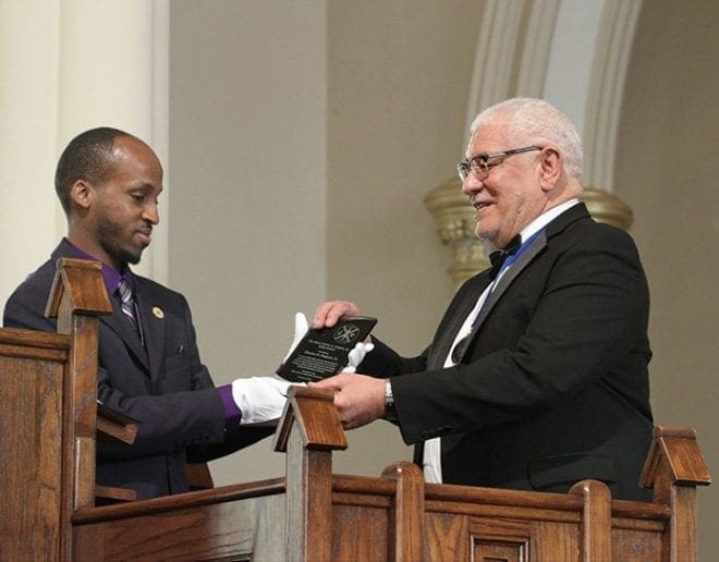Ashley Morris, left, assistant director of the Office for Black Catholic Ministry, presents the very first Charles O. Prejean Sr. Unity Award to the retiring director of the office for whom the new award is named. Beginning in 2016 the Charles O. Prejean Sr. Unity Award will be presented to a worthy parishioner who works tirelessly to promote unity around the archdiocese. Photo By Michael Alexander