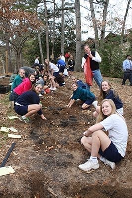 The eighth-grade class at St. Jude the Apostle School plants flower bulbs as part of the Daffodil Project on Dec. 19. The project aims to build a Holocaust memorial of 1.5 million daffodils around the world in memory of the 1.5 million children murdered during the Holocaust. They were planted between the rectory/church and the school along the path of the Stations of the Cross.