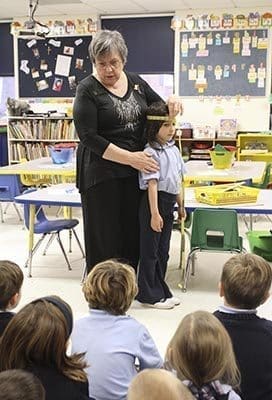 Kathy Merritt demonstrates the use of a tape measure with the help of 5-year-old kindergarten student Ainslee Williams. On this particular morning Merritt is introducing the concept of measurement to her students. Photo By Michael Alexander