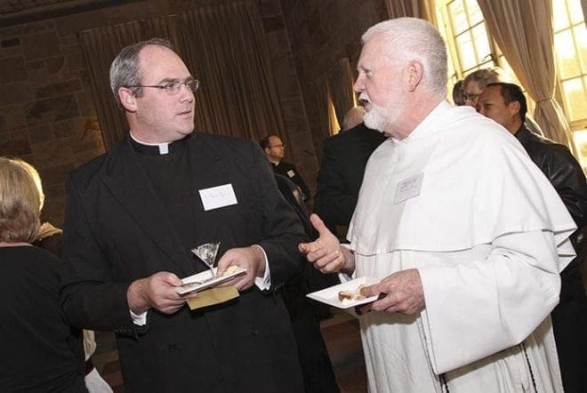 Legionaries of Christ Father Thomas Flynn, left, and Dominican Father John Boll converse with each other during the reception at the Monastery of the Holy Spirit. Father Flynn and Father Boll are Atlanta chaplains at Holy Spirit Preparatory School and the University Catholic Center for Emory University and Agnes Scott College, respectively. Photo By Michael Alexander
