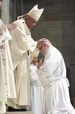 Archbishop Wilton D. Gregory lays hands upon diaconate candidate William Donohue of Prince of Peace Church, Flowery Branch. Photo By Michael Alexander 