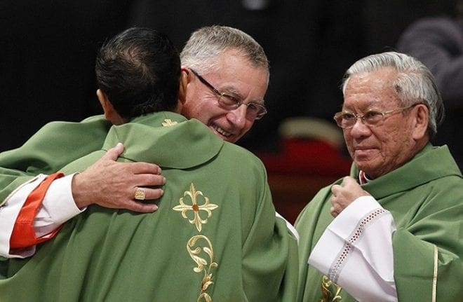 New Cardinals John Dew of Wellington, New Zealand, and Charles Bo of Yangon, Myanmar, exchange the sign of peace during a Mass with Pope Francis and new cardinals in St. Peter's Basilica at the Vatican Feb. 15. At right is new Cardinal Pierre Nguyen Van Nhon of Hanoi, Vietnam. The pope created 20 new cardinals at a consistory the previous day. CNS photo/Paul Haring