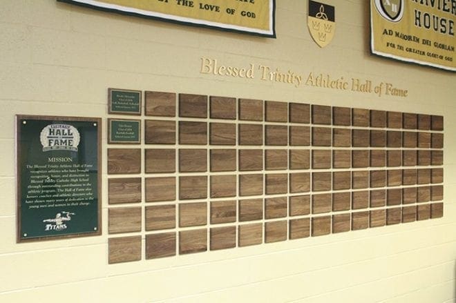 The first two inductee plaques on the wall displaying the Blessed Trinity High School Athletic Hall of Fame belong to Brooke Alexander, who excelled at golf and volleyball, and Tyler Flowers, who played football and baseball. Photo By Michael Alexander