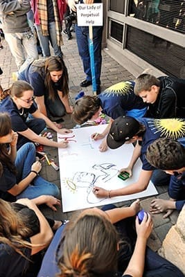 Students from Our Lady of Perpetual Help Church, Carrollton, create a poster as part of the activities at the Middle School CatholicFest. Along with arts and crafts, the day included adoration and talks. Photo By Lee Depkin