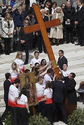 Young people from Poland raise the World Youth Day cross after accepting it from Brazilian youths at the conclusion of Pope Francis' celebration of Palm Sunday Mass in St. Peter's Square at the Vatican April 13. The next international Catholic youth gathering will be July 25-Aug. 1, 2016, in Krakow, Poland. CNS photo/Paul Haring