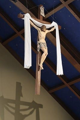 Draped in the white of the resurrected Christ, the 146-pound crucifix, with its six-foot corpus, was hand carved and hand painted in Italy. Photo By Michael Alexander