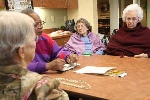 David Waters, second from left, leads the rosary last November as Virginia Stearns, far right, joins a host of fellow residents, including Pat Swenson, far left, and Trudy Melun, second from right. Photo By Michael Alexander