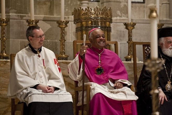 Archbishop Wilton D. Gregory, center, and Father Paul A. Burke, left, listen to the keynote address by Jesuit Father Joseph McShane, president of Fordham University, New York. Photo By Jessie Parks