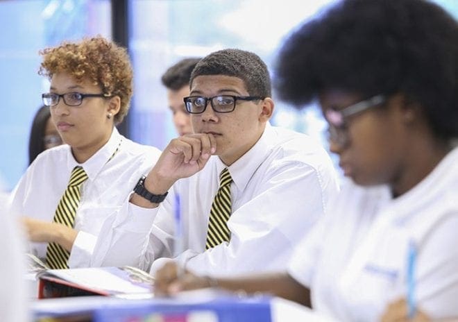 Sean McNeal, center, looks toward the front of the room during a lecture in his biology class. McNeal found his first year at Cristo Rey Atlanta Jesuit High School a challenge at times, but he knows that all the effort and hard work will pay off at the end of the four years. Photo By Michael Alexander