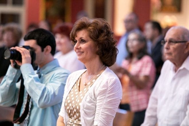 Dalila Garcia, wife of Deacon Carlos Garcia, watches as her son, Father Michael Garcia of Miami, celebrates his first Mass following ordination on May 9 at St. Agatha Parish in Miami, where the family worshiped prior to coming to Atlanta. Shown left is her younger son, William, taking a photo of his brother. Father Garcia is to visit his family in Georgia and celebrate Mass at their parish, St. John Vianney, Lithia Springs, the weekend of May 30-31. Photo By Tom Tracy