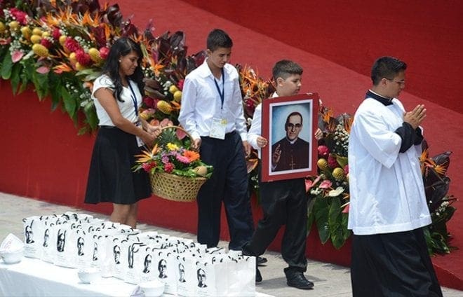 Pilgrims carry flowers and a portrait of Archbishop Oscar Romero during his beatification Mass. CNS photo/Lissette Lemus 