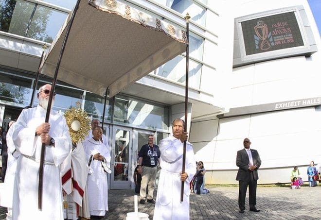 Archbishop Wilton D. Gregory prepares to carry the monstrance holding the Real Presence of Jesus in the Eucharist to the main exhibit hall of the Georgia International Convention Center, College Park, during the morning procession June 6. Photo By Michael Alexander