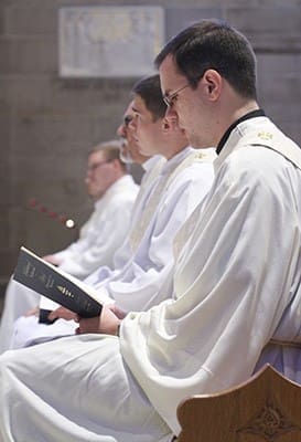 The ordination candidates (foreground to background) Brian Bufford, Branson Hipp, Mark Thomas, Timothy E. Nadolski and Jorge Carranza sit before the altar during the singing of the responsorial psalm. Photo By Michael Alexander