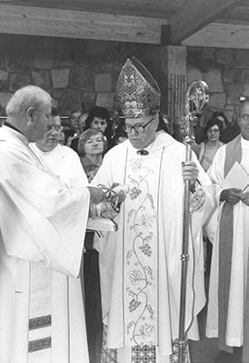 Missionaries of Our Lady of La Salette Father Robert Dyer, left, the pastor of St. Thomas the Apostle Church, hands over a key and decree of dedication for the new sanctuary to Archbishop Thomas A. Donnellan on Nov. 23, 1985. Photo By Burtenshaw