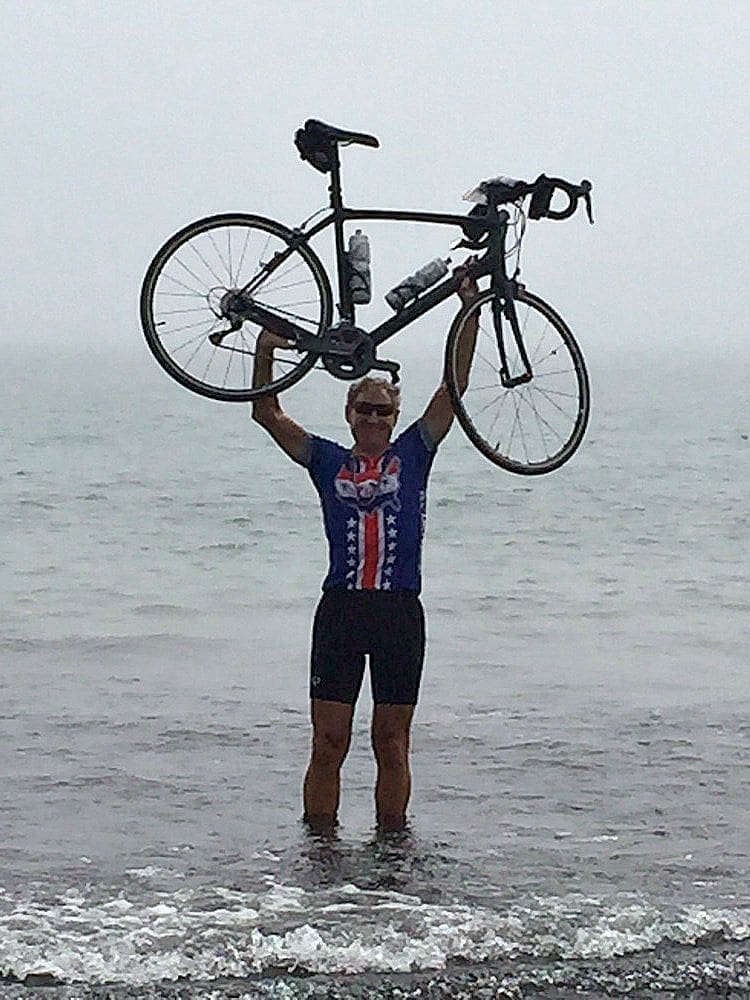 Cyclist Dick Marklein celebrates his cross-country bike ride in New Hampshire. He took his bike into the Atlantic Ocean.